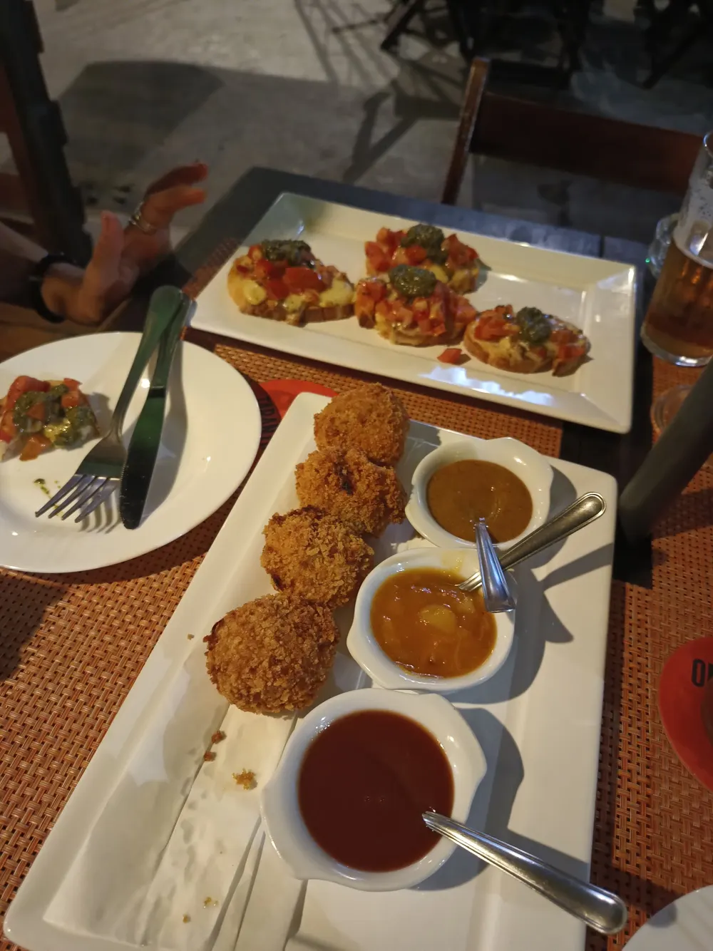 Petiscos com molhos da casa servidos em travessas