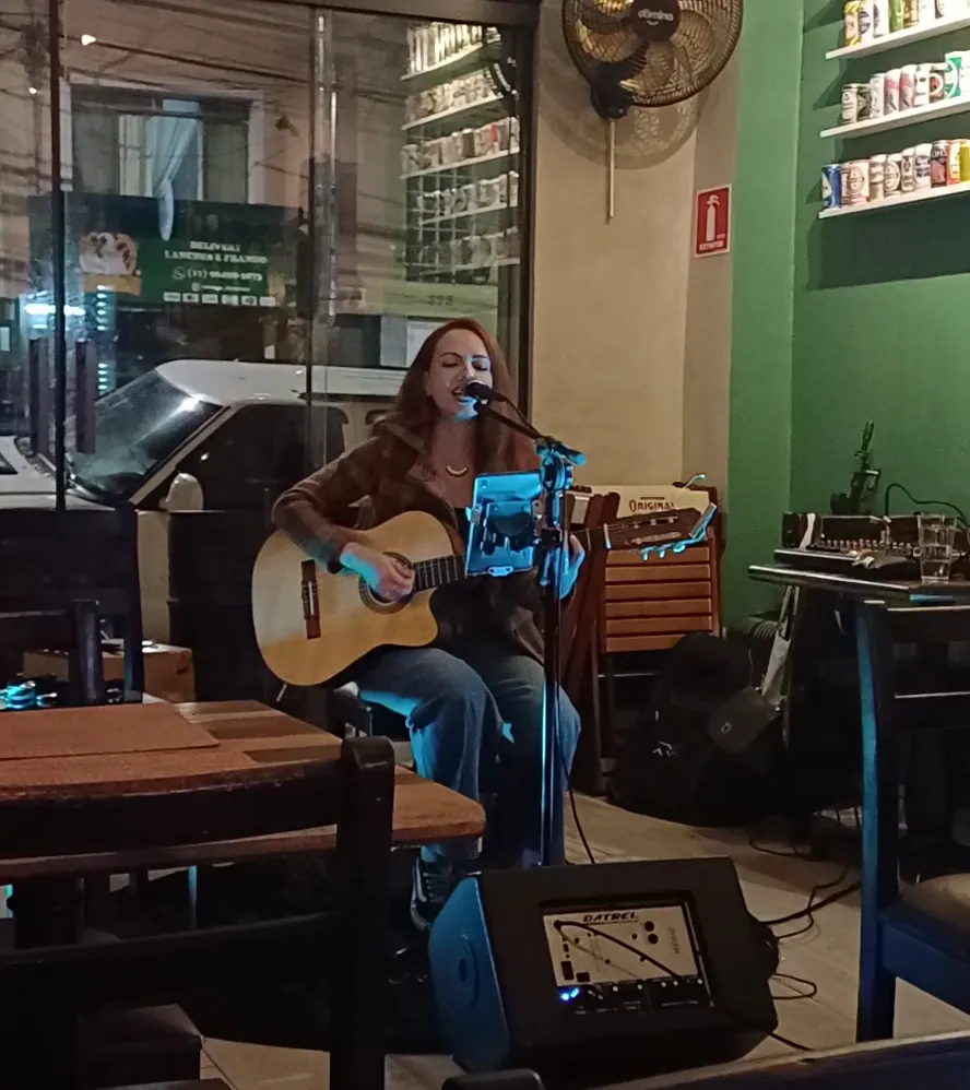 Apresentação com voz e violão no salão do Oink